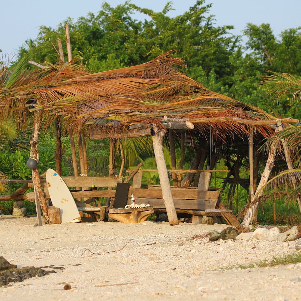 Beach shelter with surfboard at Asu Camp