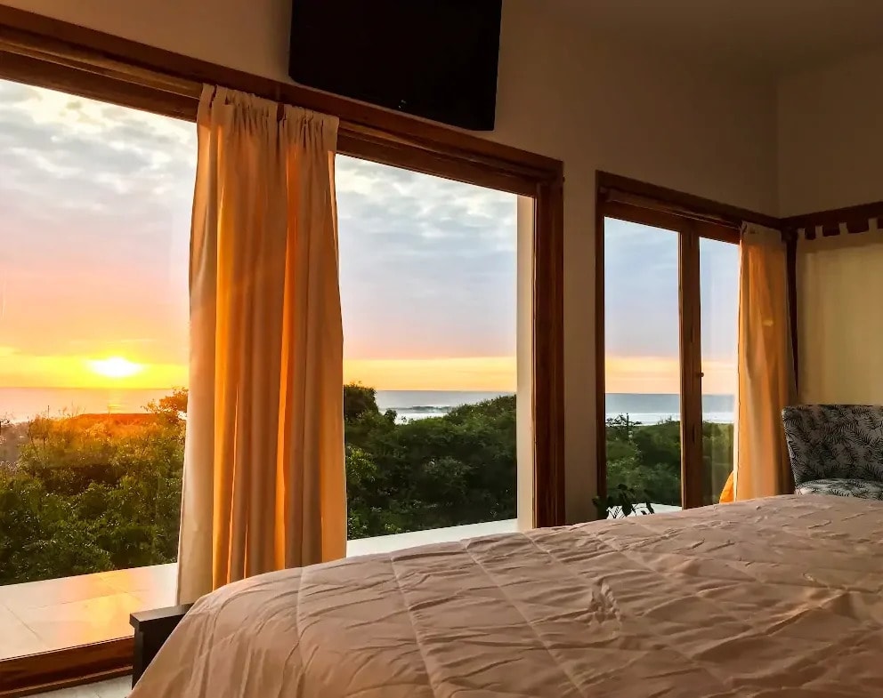 The sun going down over the water through a bedroom window