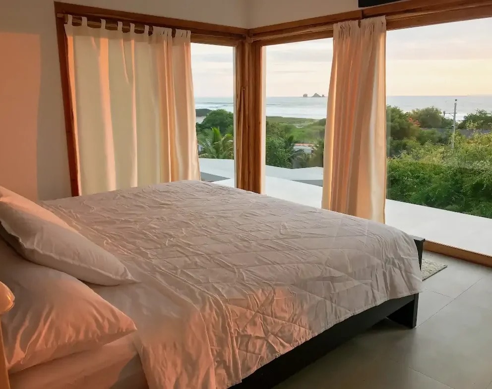 A bed facing full height windows, the surf and the Ahorcados rocks beyond