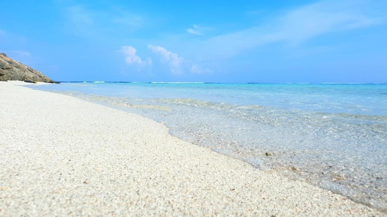 Empty white sand beach and clear water near Himmafushi