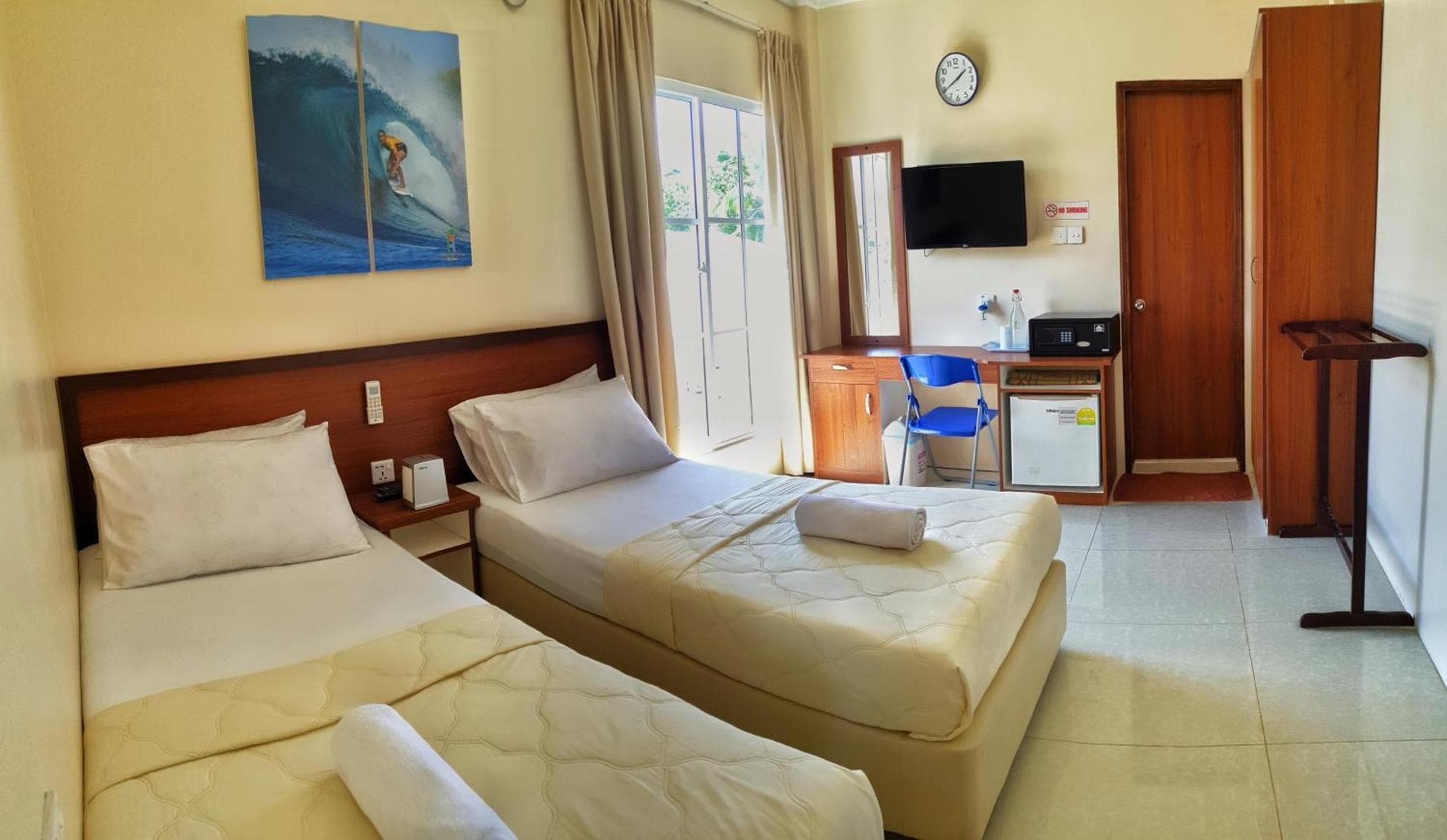 Twin room with surf artwork above the beds at Aria Holiday Maldives