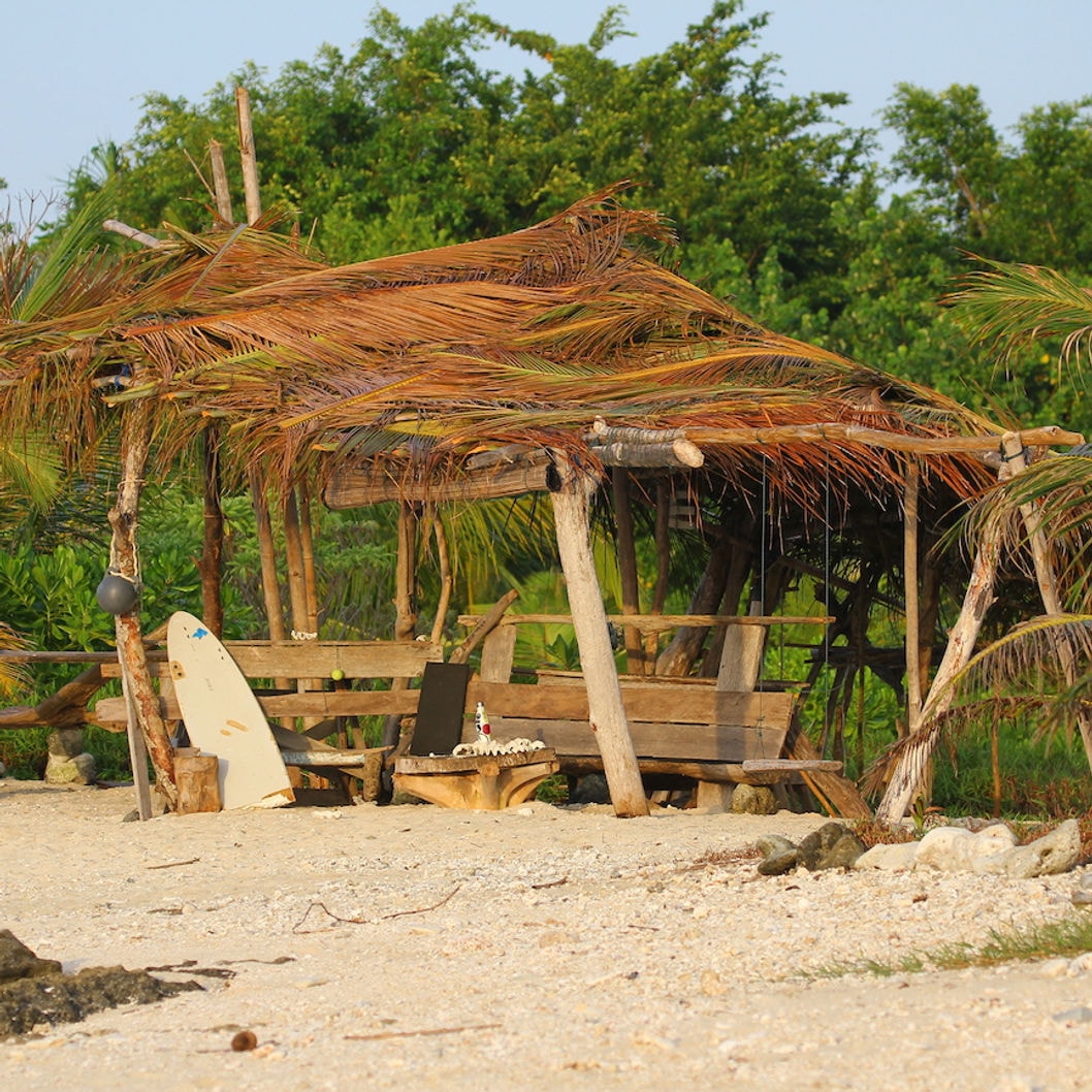 Beach shelter with surfboard at Asu Camp