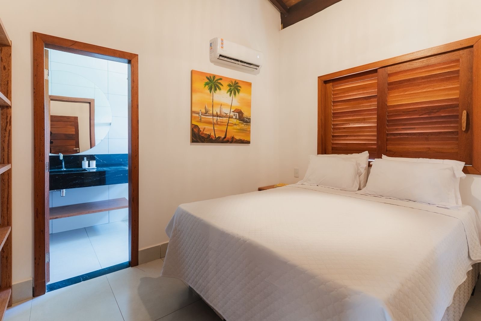 Bedroom with a king bed, air conditioning, louvered wooden shutters and an ensuite bathroom