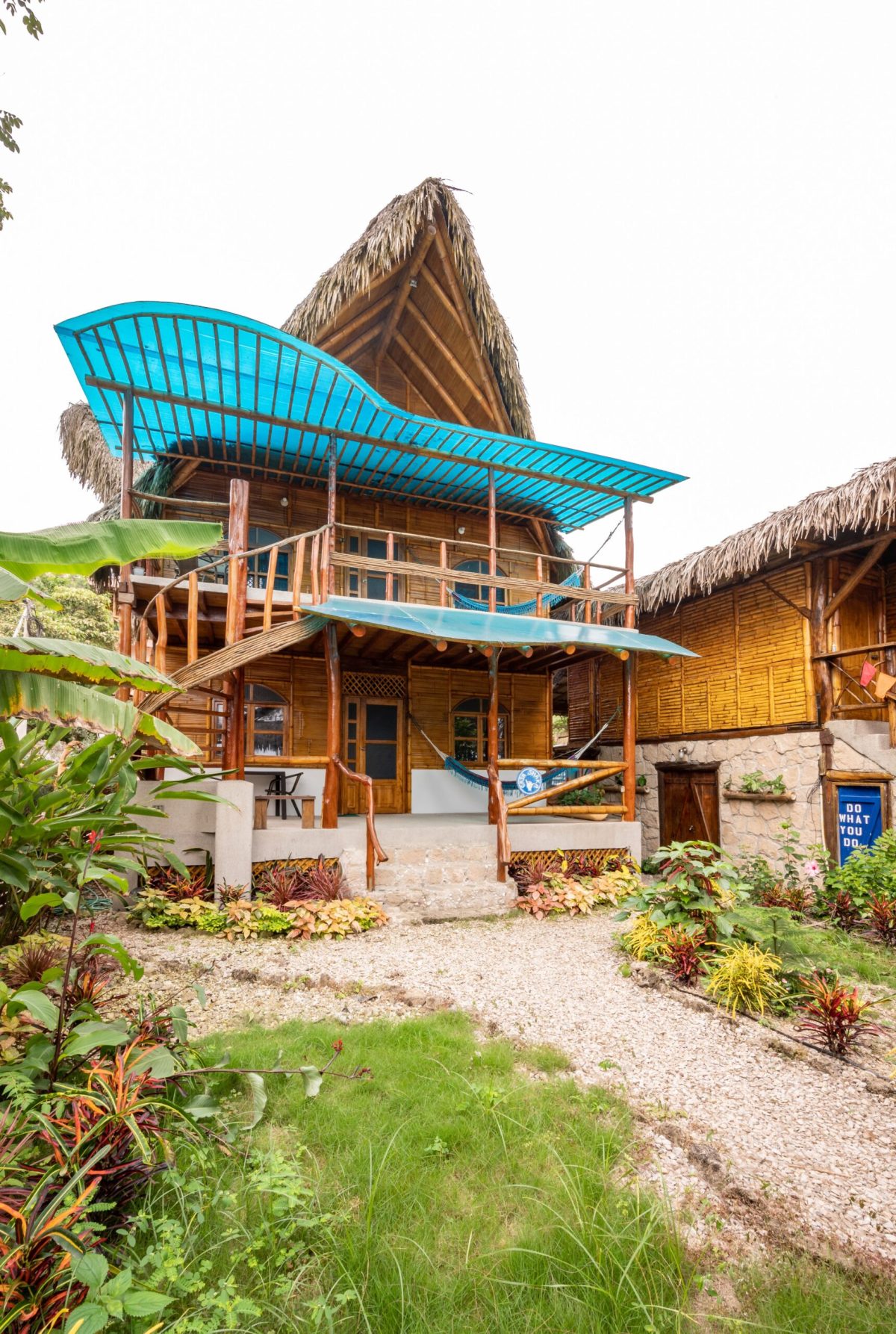 The bamboo and thatch building at Casa del Sol, with blue awnings and hammocks on both levels