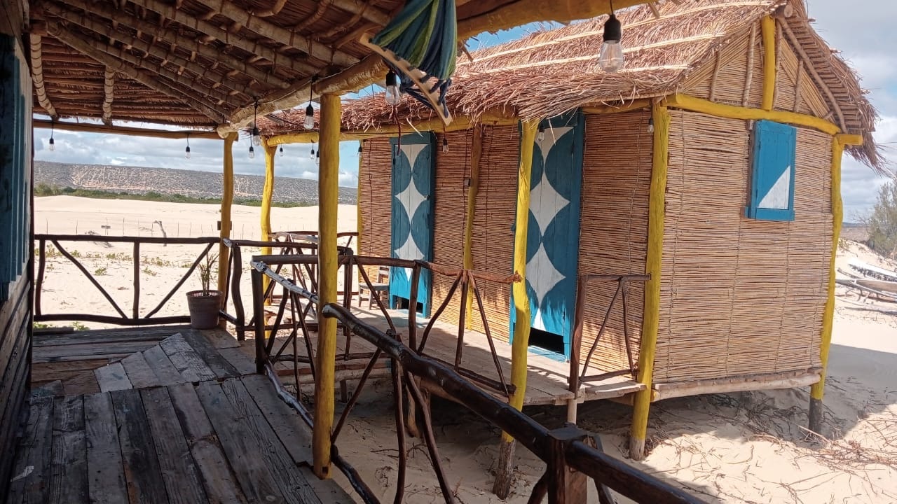 Thatched bungalow at Chez Andrea with a shaded terrace above the sand