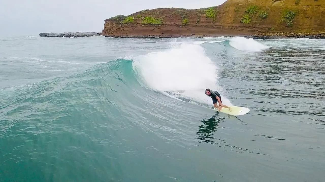 Surfer riding a wave at La Punta point break in Montañita