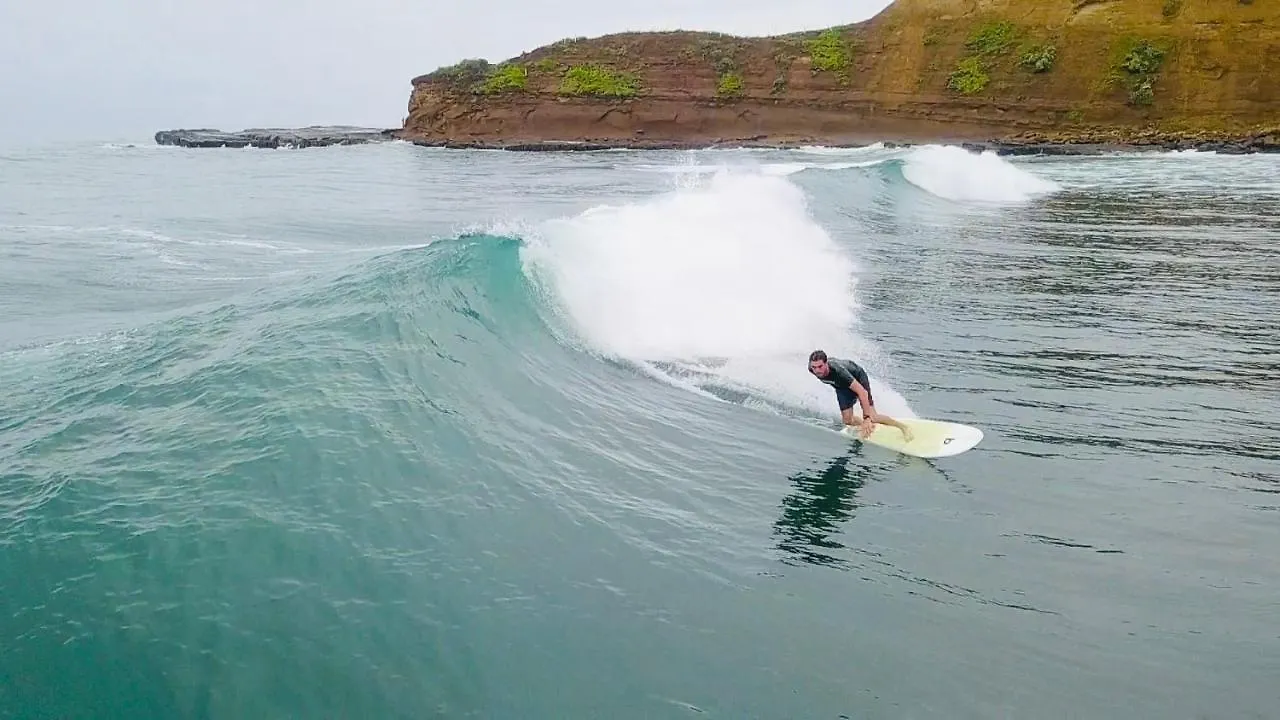 Surfer riding a wave at La Punta point break in Montañita